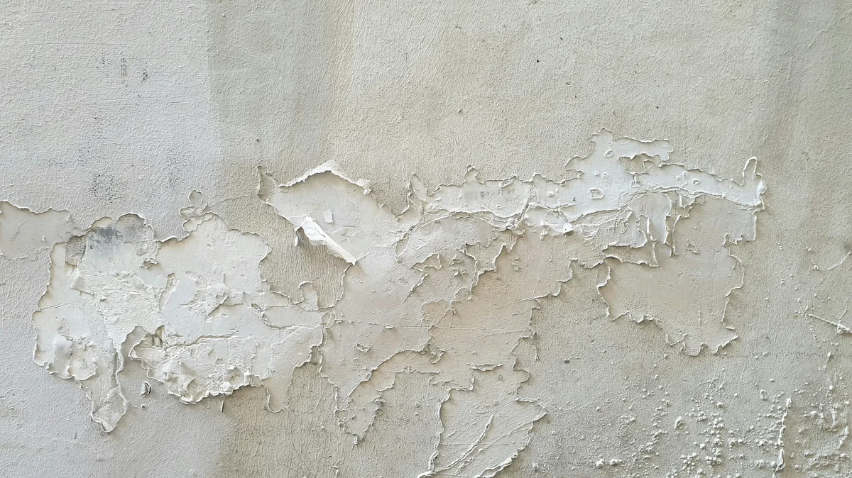 Mur avec peinture écaillée par l'humidité, signe de problème d'humidité à traiter