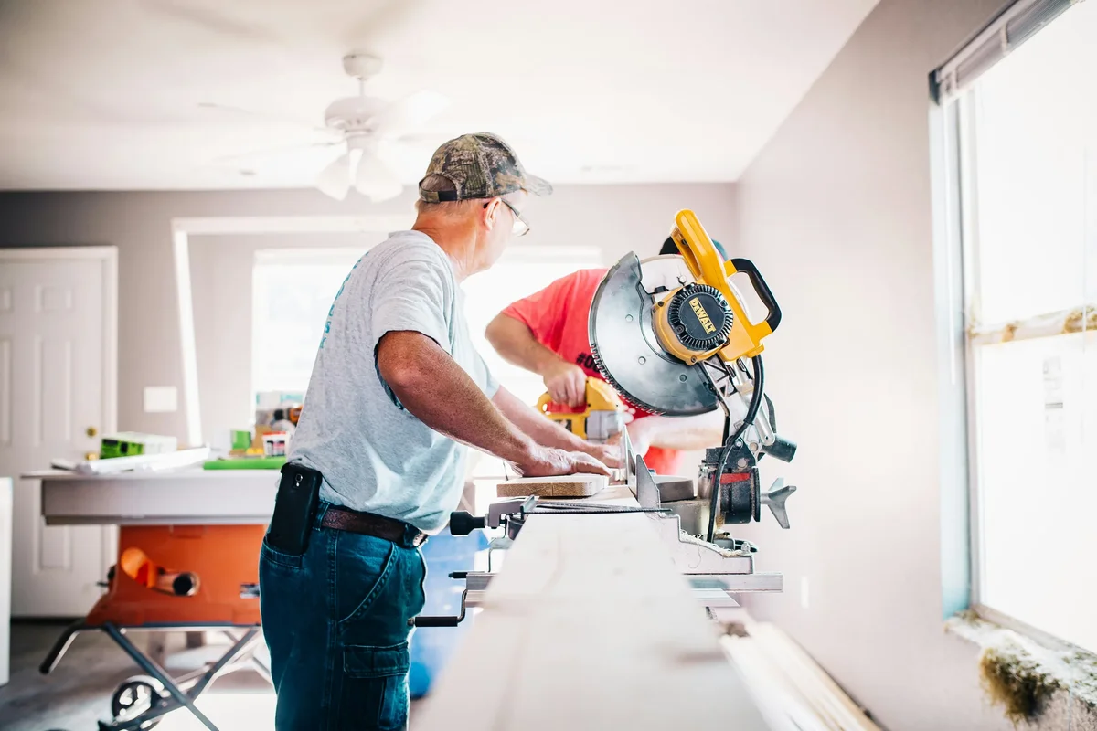 Arbeiders die een verstekzaag gebruiken tijdens een binnenrenovatie